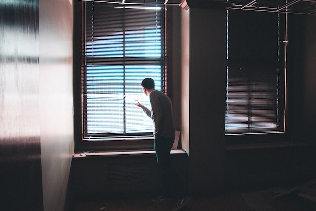 man standing near window inside building