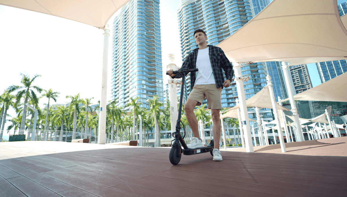 person standing and holding scooter