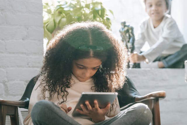 serious-ethnic-little-girl-using-tablet